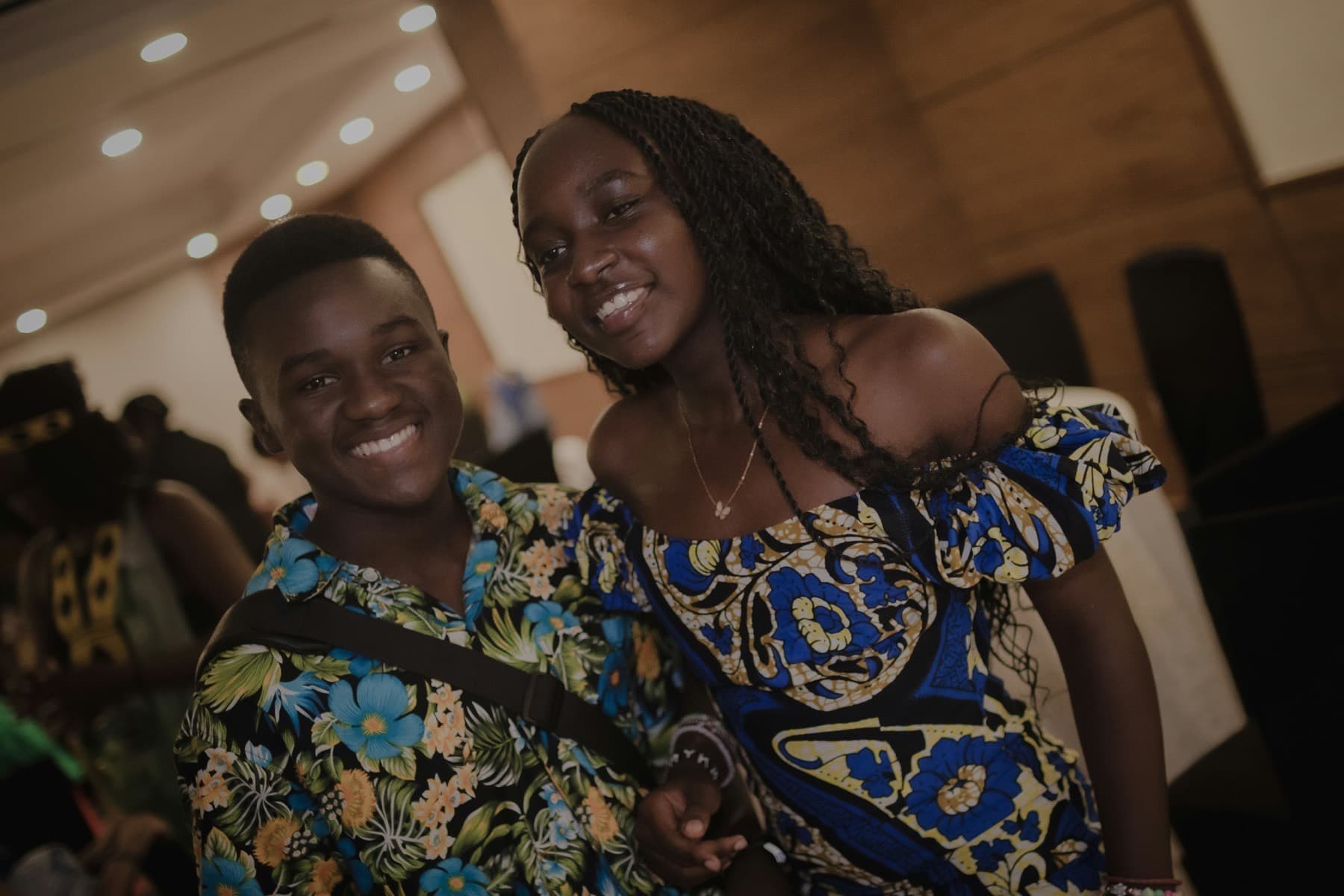 Smiling young man and woman posing together at an evening gathering